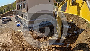 POV: Using a Caterpillar excavator to excavate soil near an unfinished house.