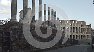 Pov on Via Sacra in ancient Rome downtown with archaeological remains of colonnades and view of Colosseum or Amphitheatrum Flavium
