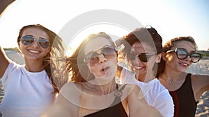 Pov view of pretty women take selfie having fun with drinks on sea beach on sunset. Online video call: girl looking at