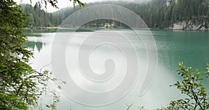 POV walking thru forest to see Braies lake landscape. Group of friends summer adventure journey in mountain nature