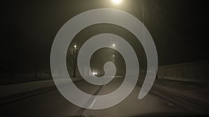 POV wide view of car ride on dark fog night road