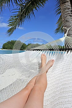 POV of a woman lay on a hammock relaxing in Muri lagoon in Rarotonga Cook Islands