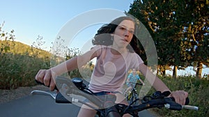 POV of a young girl enjoying a bicycle ride on the rural countryside