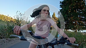 POV of a young girl enjoying a bicycle ride on the rural countryside