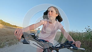 POV of a young girl enjoying a bicycle ride on the rural countryside