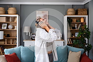 POV of young happy woman or girl dancing in the new apartment in boyfriend shirt and wireless headset happy that she and her