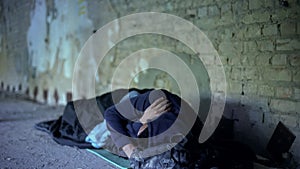 Poverty, homeless young man sleeping on street, indifferent egoistic society