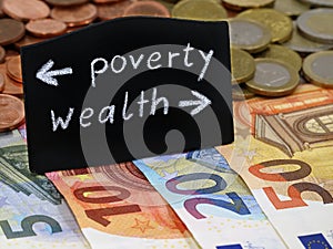 Poverty and wealth shows the way on a blackboard on euro banknotes, divided society between poor and rich photo