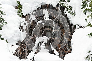 Powder Framed Winter Waterfall with Snow Melt Trickling Over Rocks