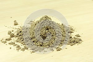 Powder grains of cardamom on wooden