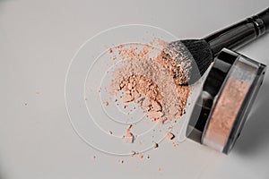 Powder hill, black makeup brush, a jar of powder lying on the edge