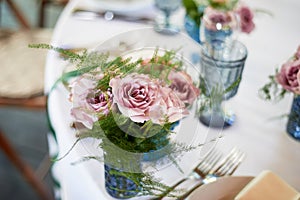 Powder roses in small blue vases.Wedding decor or romantic date design. Floristics.