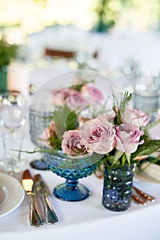 Powder roses in small blue vases.Wedding decor or romantic date design. Floristics. photo