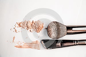 Powder slide, a touch of foundation and two black makeup brushes