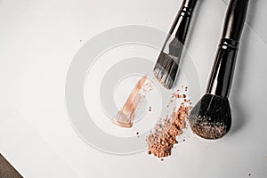 Powder slide, a touch of foundation and two black makeup brushes