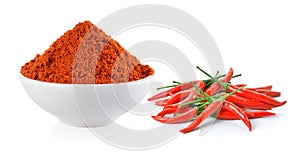 Powdered dried red pepper and red chili peppers in a white bowl