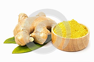 Powdered ginger in a wooden cup and fresh ginger with leaves.