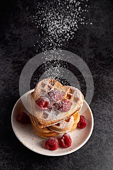 Powdered sugar falling on a stack of waffles