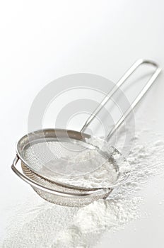 Powdered sugar in a metal strainer