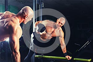 Power athletic guy , execute exercise press with dumbbells, in sport hall