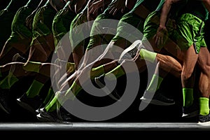 Power and athleticism. Cropped image of athletic, muscular male legs in motion, running against black background with