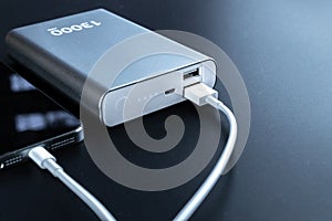 Power bank smartphone. Mobile phone or smartphone battery charging from portable powerbank with white usb cable. Modern