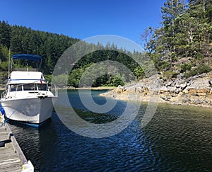 A power boat docked close to shore on a peaceful day on Cortes Island, Desolation Sound, British Columbia, Canada