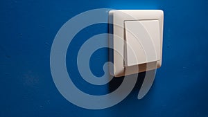 Power button on a blue wall - side view