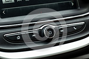 Power button and various controls of a car radio in an interior of modern vehicle