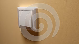 Power button on a yellow wall - side view