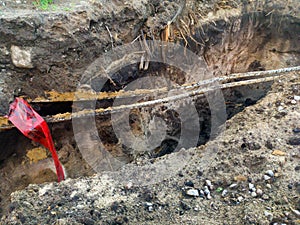 Power cable hanging over a trench in the ground