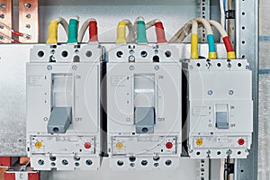 Power circuit breakers are arranged in a row in an electric Cabinet.