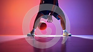 Power and control. Man, basketball player in motion, action, dribbling ball with accuracy on gradient red purple