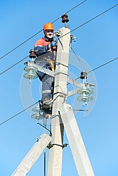 Power electrician lineman at work on pole