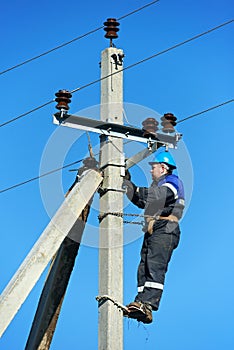 Power electrician lineman at work on pole