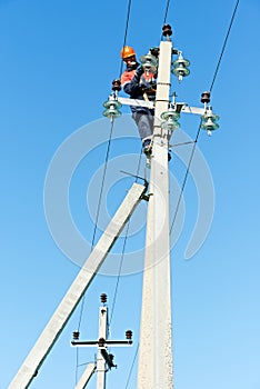 Power electrician lineman at work on pole