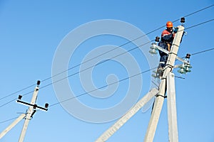 Power electrician lineman at work on pole