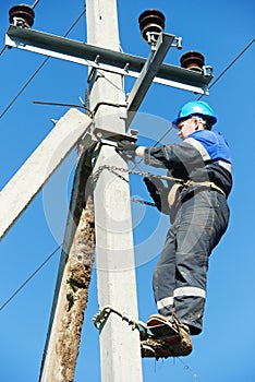 Power electrician lineman at work on pole