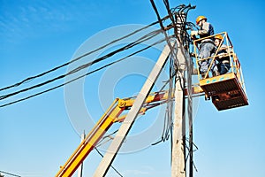 Power electrician lineman at work on pole