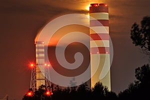 Power lights illuminated at night. Chimneys launching smoke. Cranes, extending the electron. Heat generation.