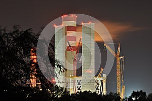 Power lights illuminated at night. Chimneys launching smoke.