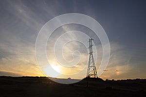 Power line against the backdrop of a landscape with a sunset, electric poles, evening