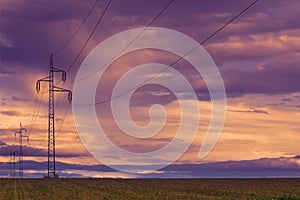 Power line and field at sunset sky.