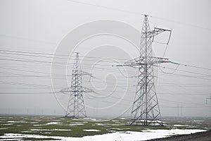 Power line. iron pillars in a foggy field.