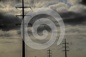 A power line pole with a cloudy sky in the background