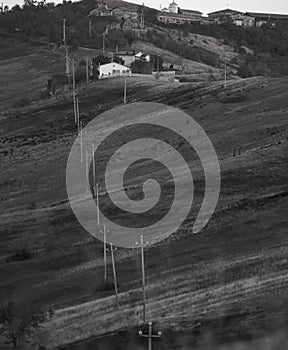 Power line poles on hill fields