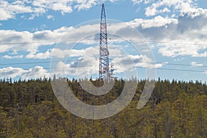 Power line post in forest. high voltage tower on the sky background