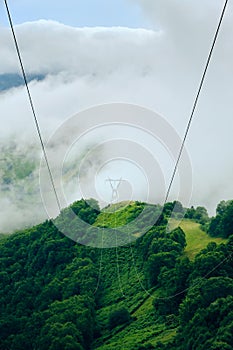 Power Line Pylon On Peak Of Mountain With Stormy Weather