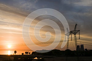 Power line support against the background of a red sunset on the