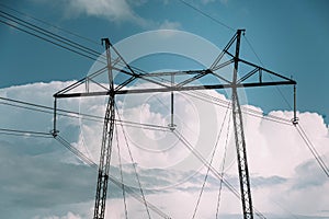 Power line tower against sky and clouds